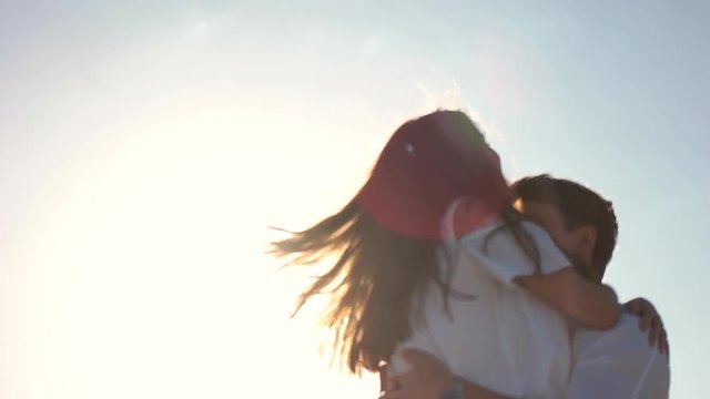 Guy holding girl in his arms and spin.