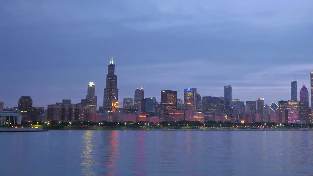 Chicago Skyline Reflected on the Lake at Sunset.
Video time lapse of Chicago downtown skyscrapers reflected on the Michigan lake from sunset clouds motion to night.
