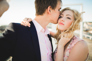 Close up portrait of happy smiling couple in love posing on roof with big balls. Landscape  city