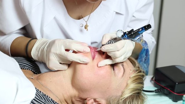 Lip tattoo woman in a beauty salon process