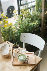 Hot green tea set on a wooden table in a coffeshop