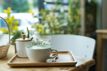 Hot green tea set on a wooden table in a coffeshop