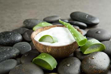 spa concept. slice aloe vera on white cream in coconut shell wit