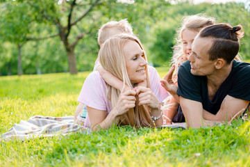 Family lying on grass in countryside