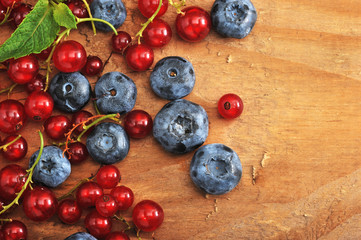 berries on wooden background. red currants and blueberries.