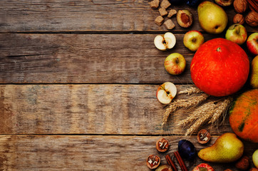 autumn wood dark background with pumpkin, fruit, nuts and wheat