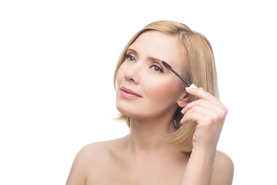 Beautiful middle aged woman applying eyebrow gel