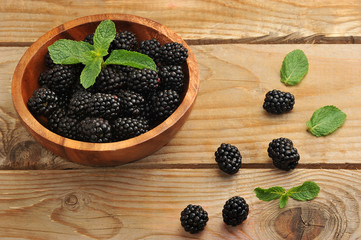 blackberries in a wooden bowl with mint leaves