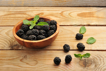 blackberries in a wooden bowl with mint leaves