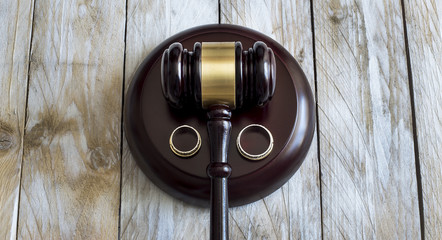 Divorce concept. Close up of wedding rings and judge gavel