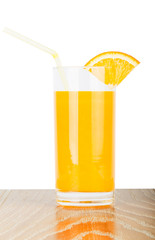 Orange juice glass with slice on wood table