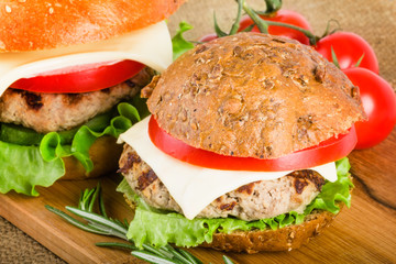 Two burgers on wood board