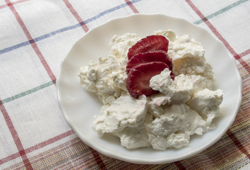 cottage cheese with slices of fresh strawberries on the plate