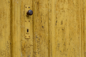 Yellow old door with doorknob and keyhole