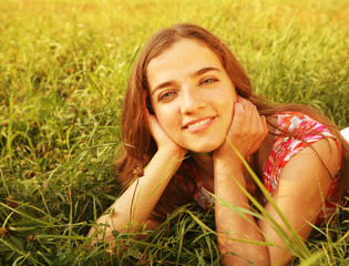 young beautiful girl lays on a grass 