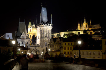 Fototapeta na wymiar Colorful Prague gothic Castle with St. Nicholas' Cathedral and Bridge Tower from Charles Bridge above the River Vltava in the Night, Czech Republic