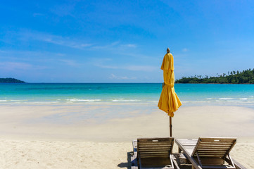Sandy tropical beach with deck chairs