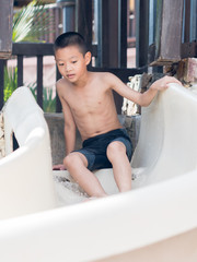 Asian boy waiting to play slider into the pool