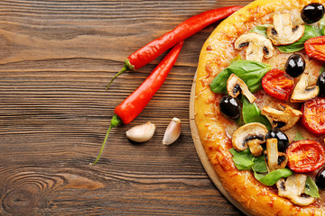 Delicious tasty pizza with ingredients on wooden table
