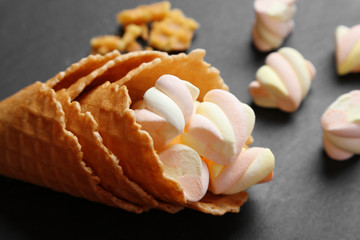 Fototapeta na wymiar Dessert in ice cream cone on dark background