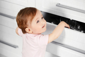 Little child playing with drawer