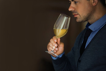 Handsome man tasting white wine