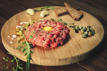 Tasty steak tartar on wooden board