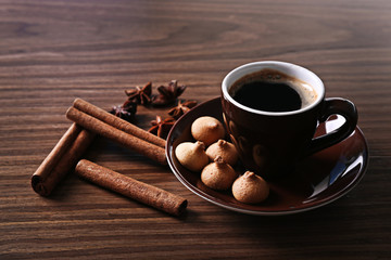Cup of coffee with cookies on wooden table