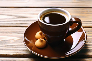 Cup of coffee with cookies on wooden table