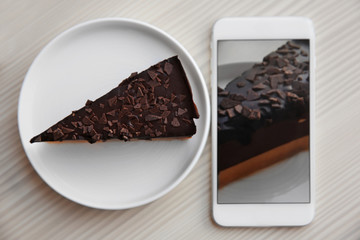 Cellphone with chocolate cake. Food blog concept