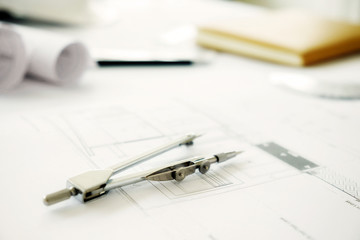Desk of Engineering project with computer, engineering tools, book, blueprint and safety helmet on desk. Construction concept. Vintage tone retro filter effect,soft focus(selective focus)