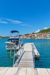 Obraz premium Small boat anchored in the Prvic Luka port at beautiful summer day in Croatia.