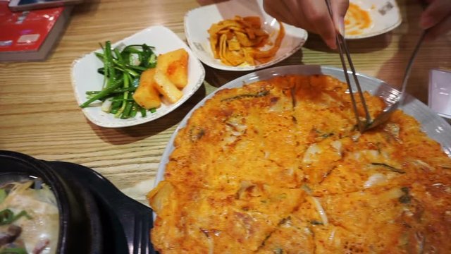 Korean food, kimchi pancake, ginseng chicken soup and variety of side dishes