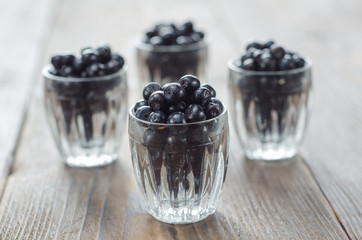 Blueberries in a glass bowl. Wooden background