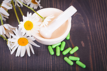 Chamomile flowers and green phytotherapeutic capsules