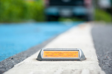 the soft focus of reflector or stud on asphalt road