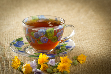 glass mug of tea with yellow and blue flowers