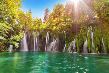 Amazing waterfall in Plitvice Lakes National Park, Croatia, Europe. Majestic view with turquoise water and sunset sunny beams, travel destinations background