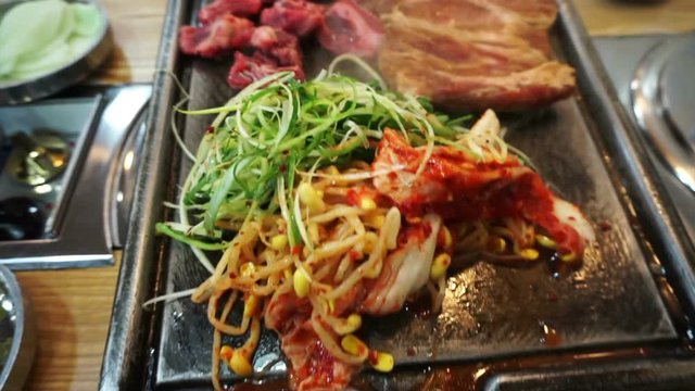 Traditional Korean barbecue and side dishes vegetable food. Grilled on big stone plate 