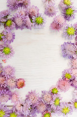 Bright summer flowers frame on white background. Bunch of purple flowers with copyspace in center
