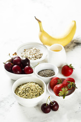 Healthy food. Fruits, seeds and berries on white table