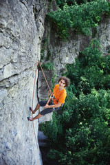 male rock climber. rock climber climbs on a rocky wall. man resting hanging on a rope