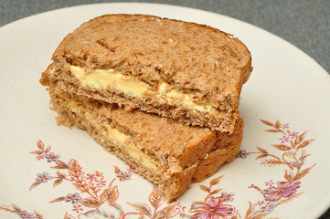 A cheese spread whole wheat sandwich on a plate