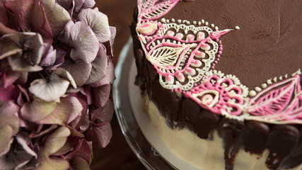 Sponge cake with mehendi patterns on glass stand. Close-up.