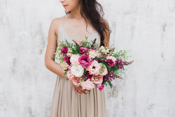Сhic wedding bouquet of peonies and roses in hands of the bride