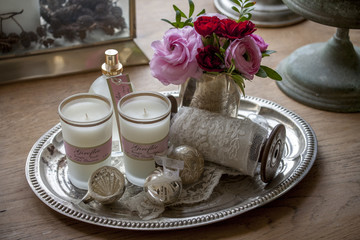 candle lights roses on a silver plate