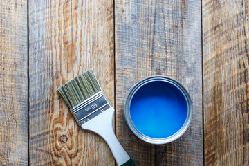 open paint jar and brush on wooden background top view