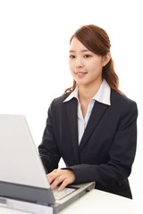 ノートパソコンで仕事中のビジネスウーマン
