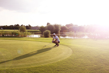 Golfer am Puttinggreen beim Sonnenuntergang