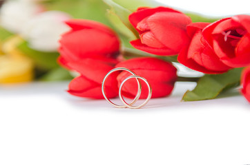 Wedding rings and flowers isolated on white background